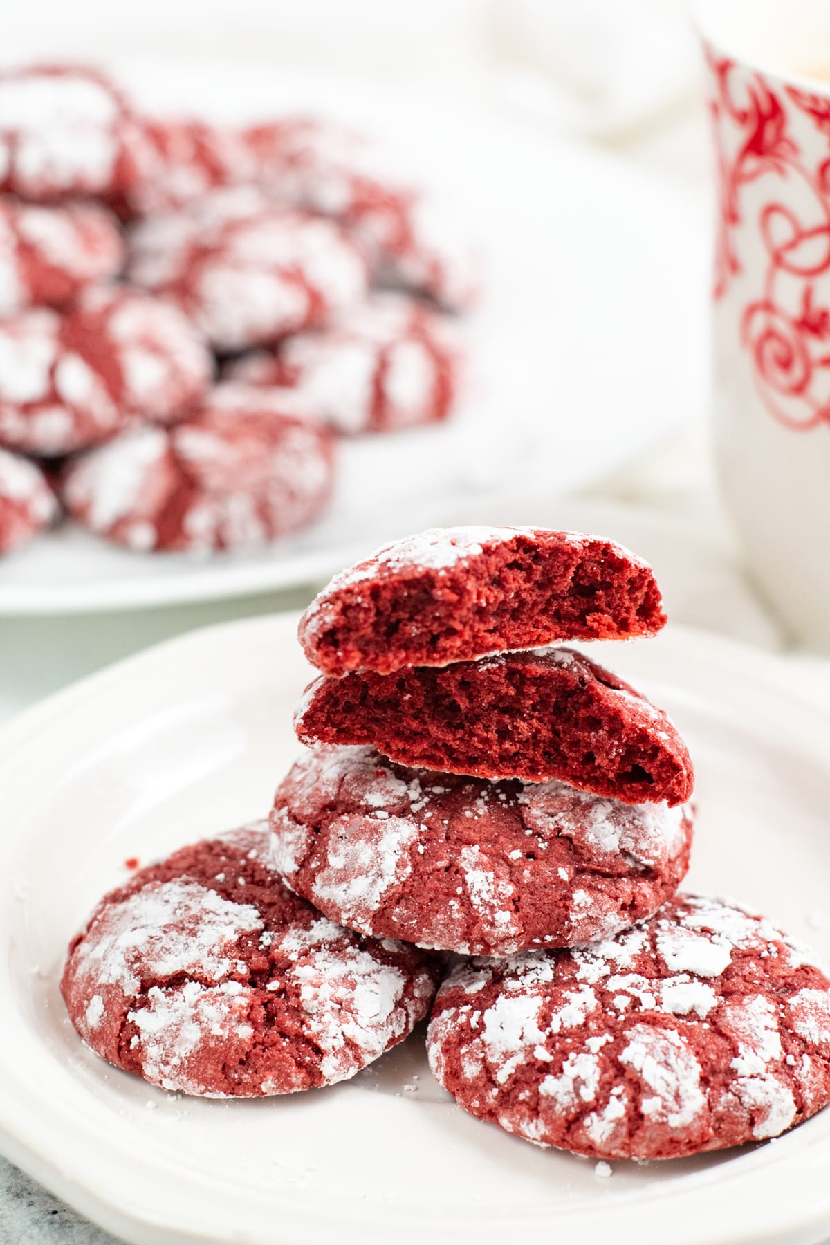 A red velvet crinkle cookies in lovely earthquake cracks coated in powdered sugar.