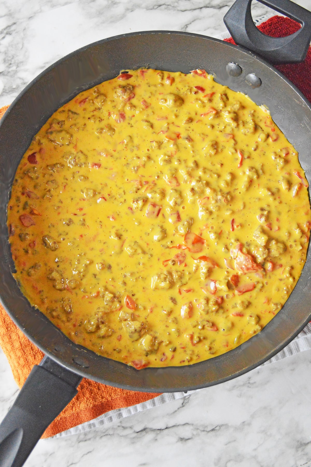 Rotel dip with sausage in a pan with melted cheese