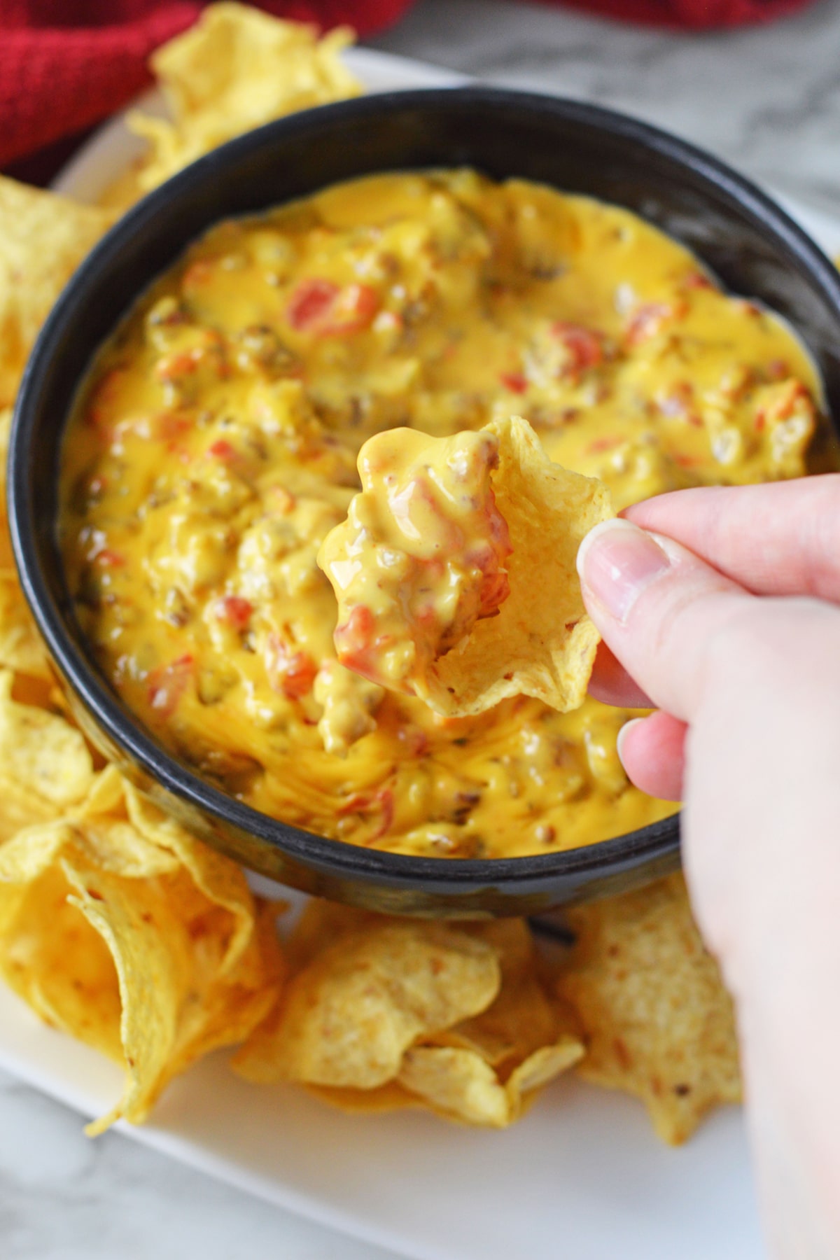 Chips dipped into the Rotel dip with sausage