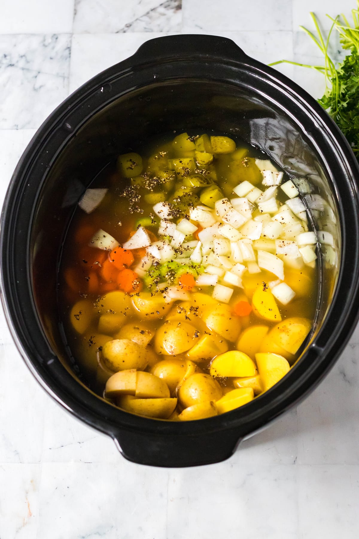 Salt and pepper are sprinkled over vegetables with pickle brine.