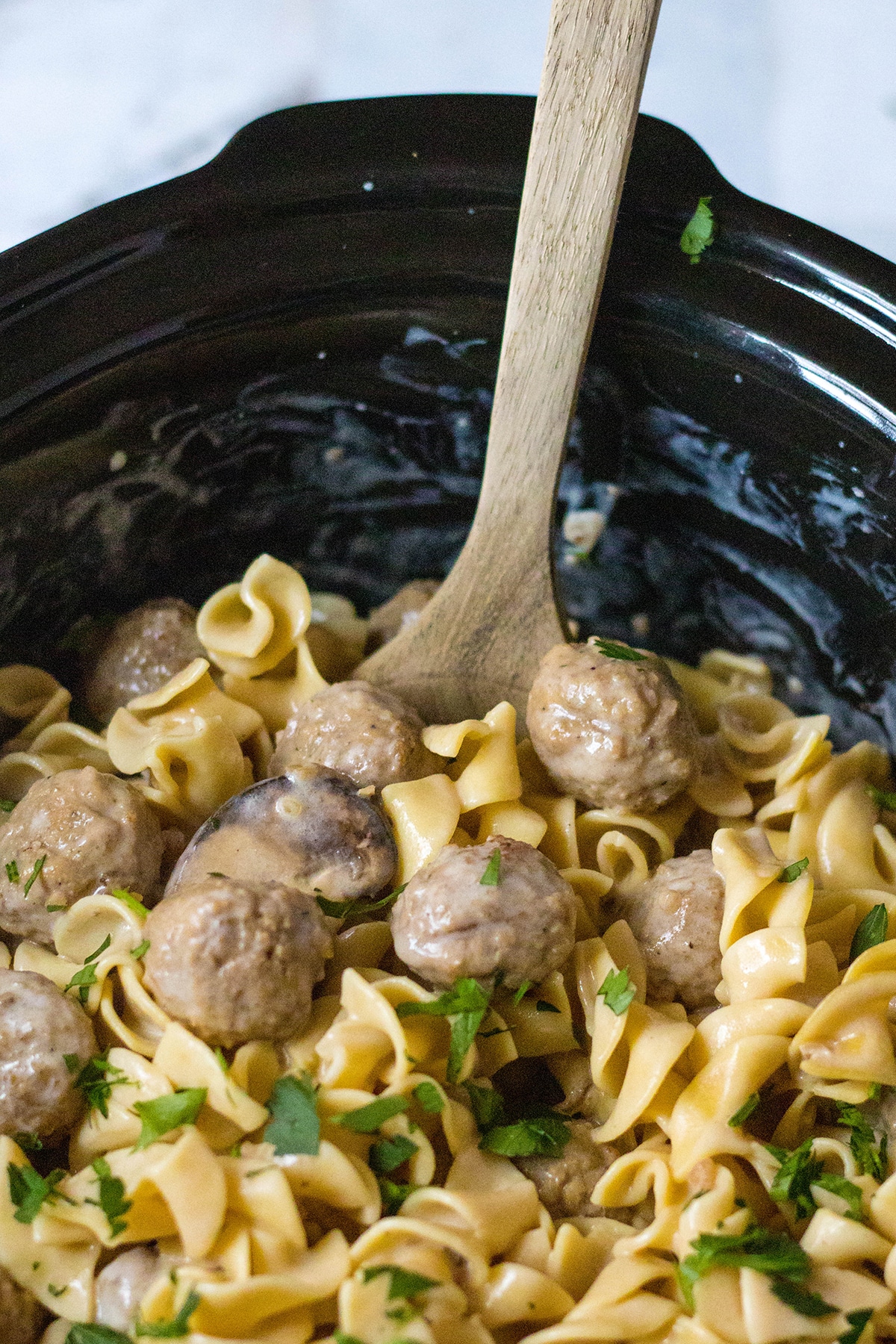 meatball stroganoff with curly noodles with parsley in a slow cooker