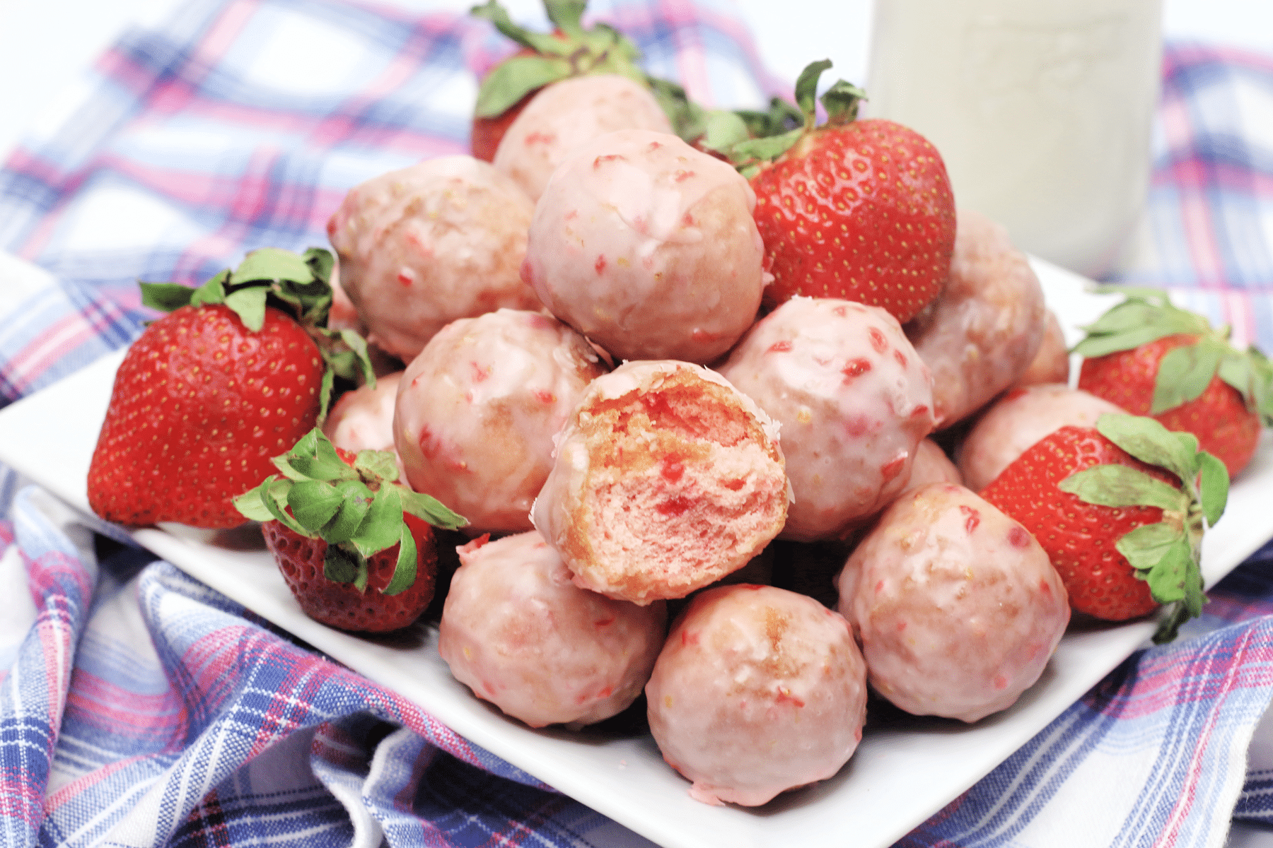 A serving of Strawberry Donut Holes with strawberries