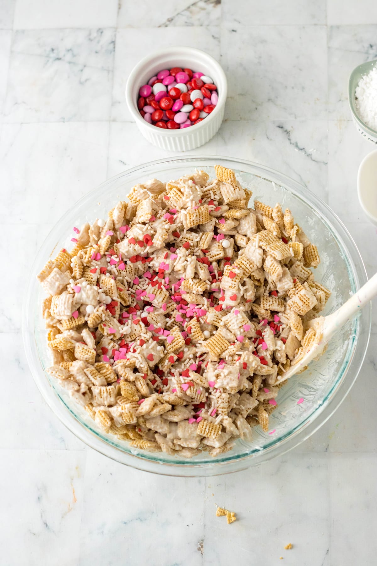 Mixing of cereal mixture and candy sprinkles in a glass bowl