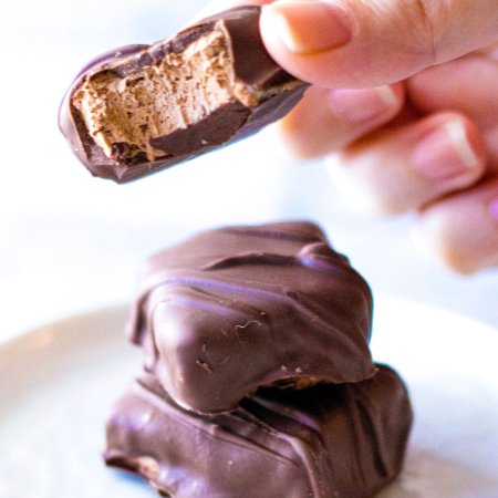 chocolate candy held up with fingers