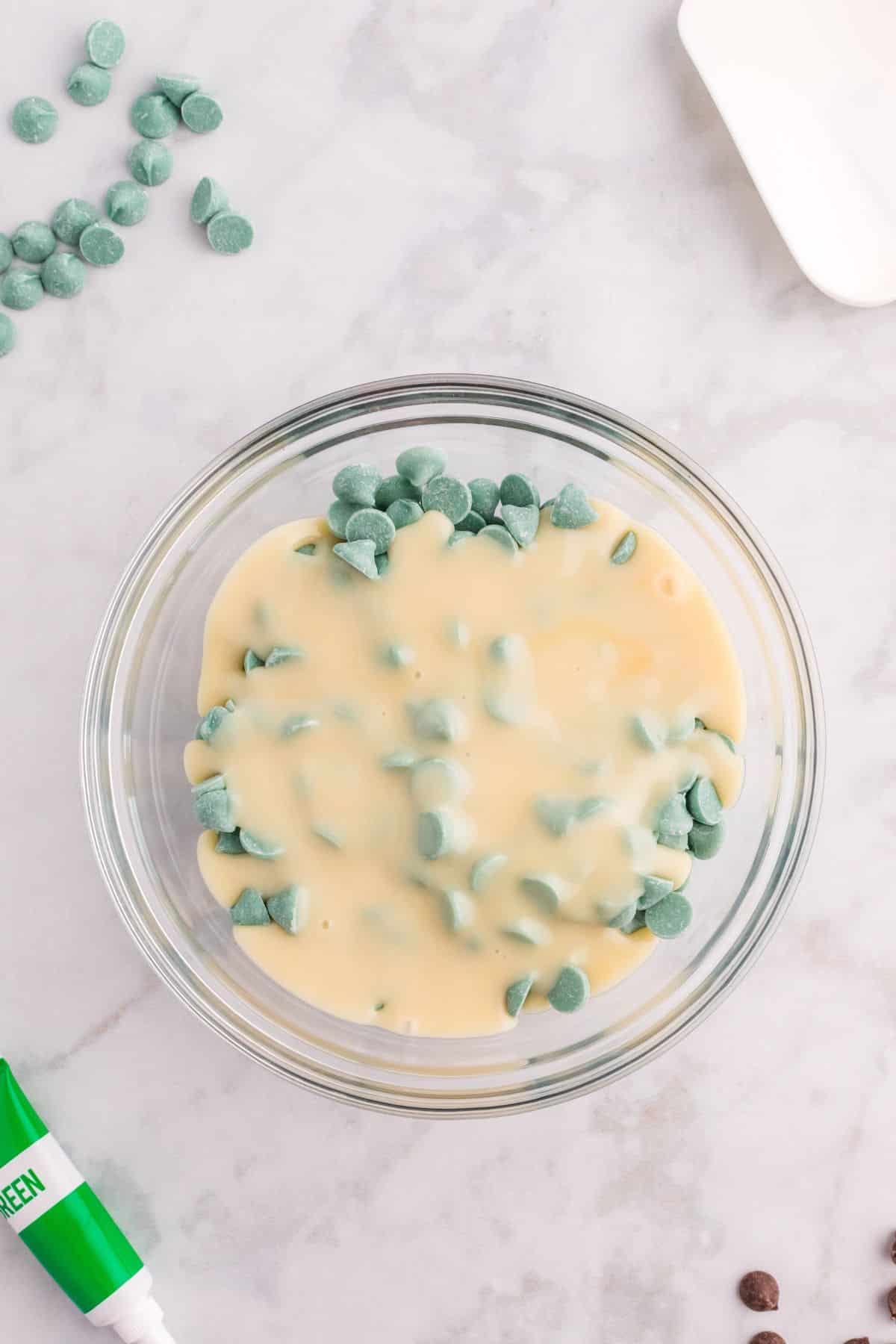 white condensed milk with green chocolate chips in bowl