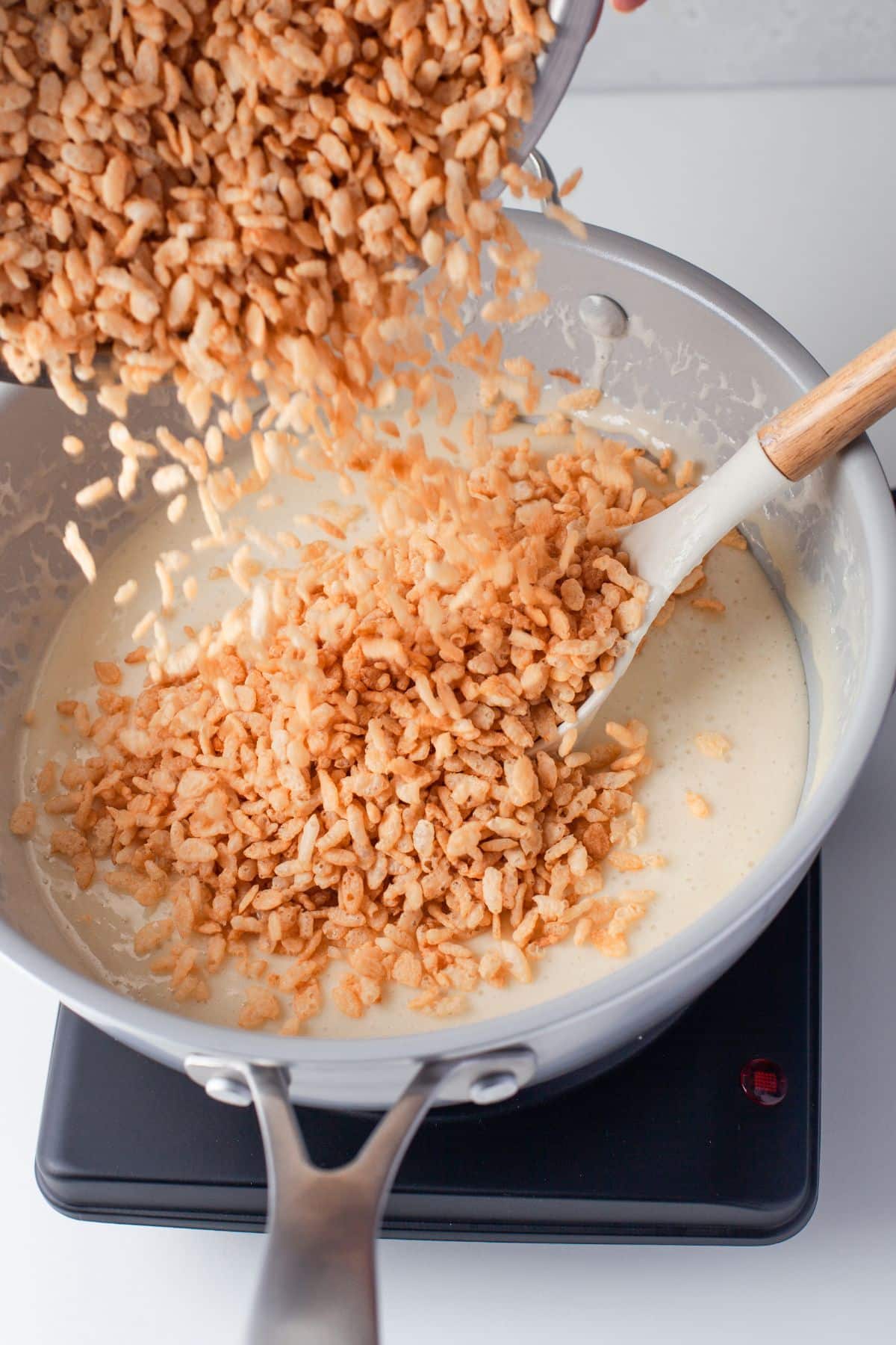 rice krispies being poured into melted marshmallow mixture