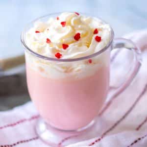 pink hot chocolate in clear glass with whipped cream
