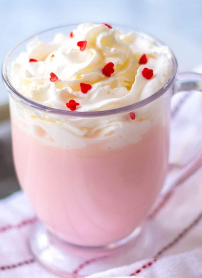 pink hot chocolate in clear glass with whipped cream