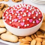bowl of dark red dip with pink heart candies and white sprinkles