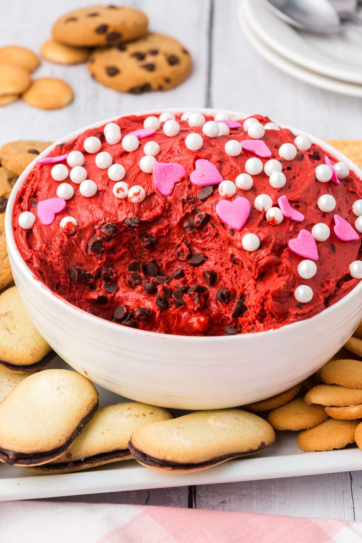 bowl with red velvet dip topped with sprinkles and chocolate chips