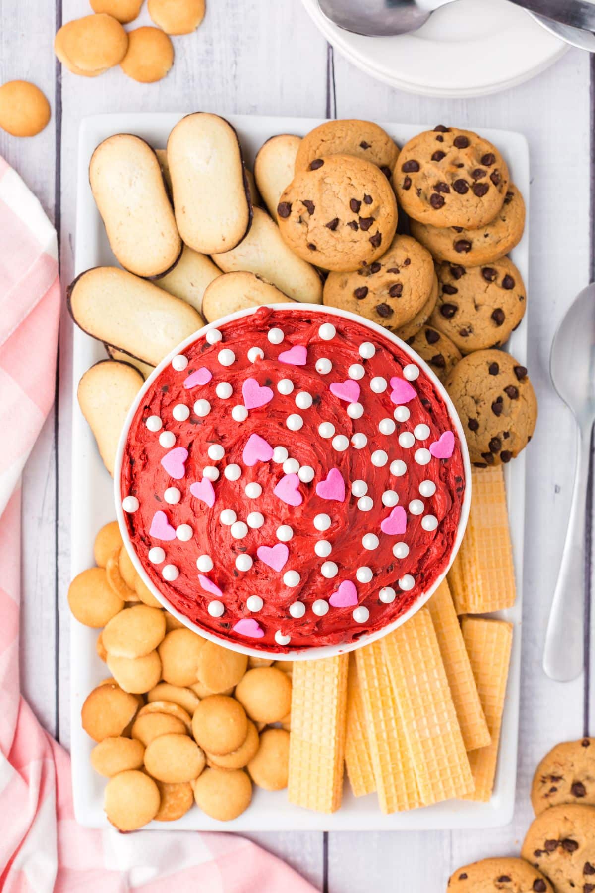 deep red dip with pink candy hearts and white sprinkles on dessert board try with cookies on the tray