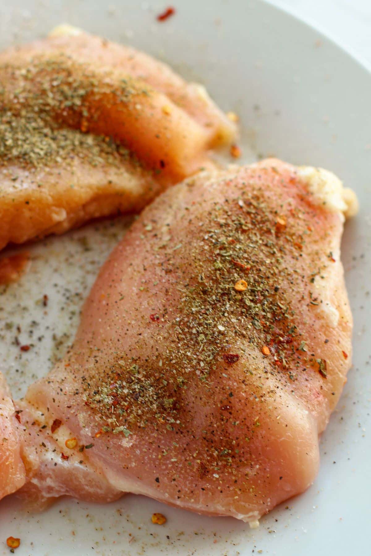raw chicken breasts with seasonings on it