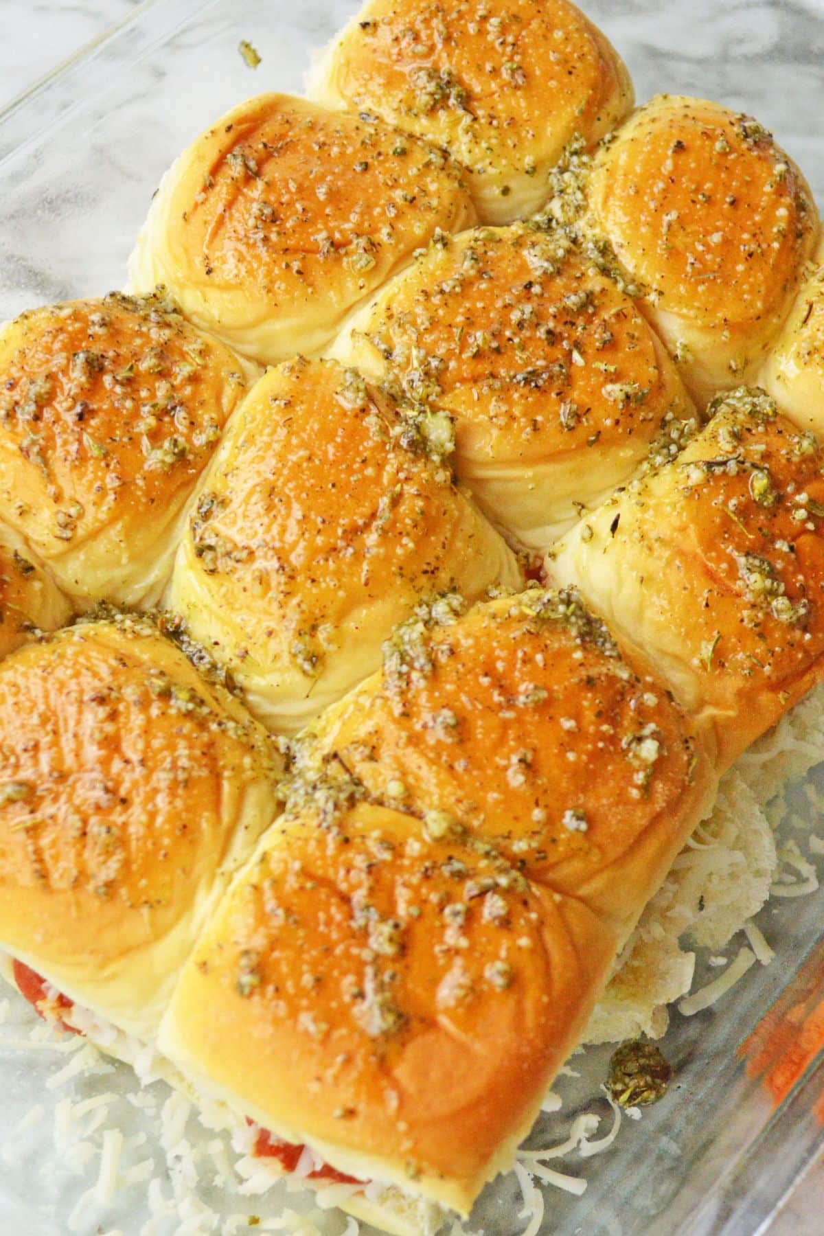 top of rolls with meatballs inside and parmesan cheese on top