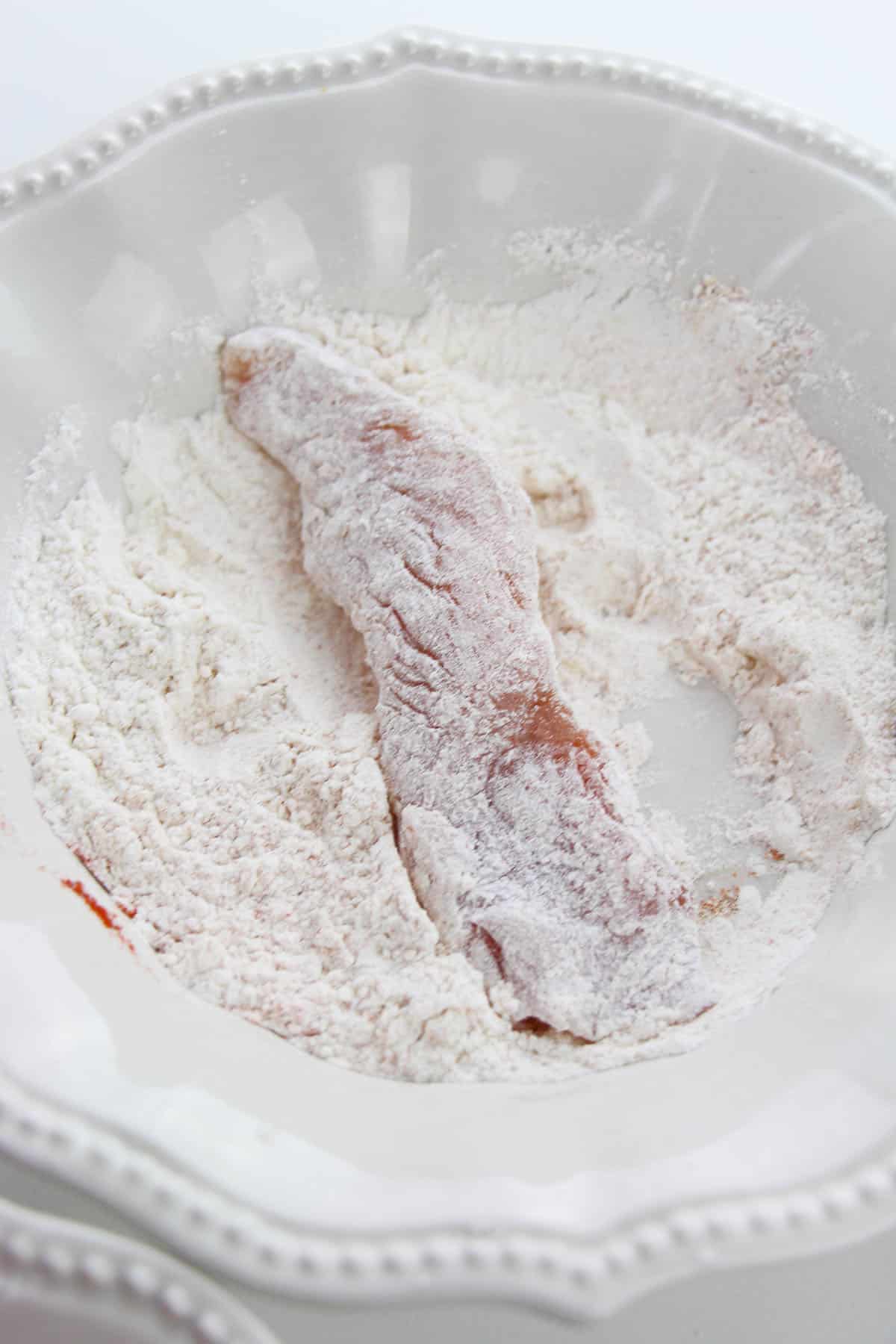 Flour mixture with a raw chicken finger