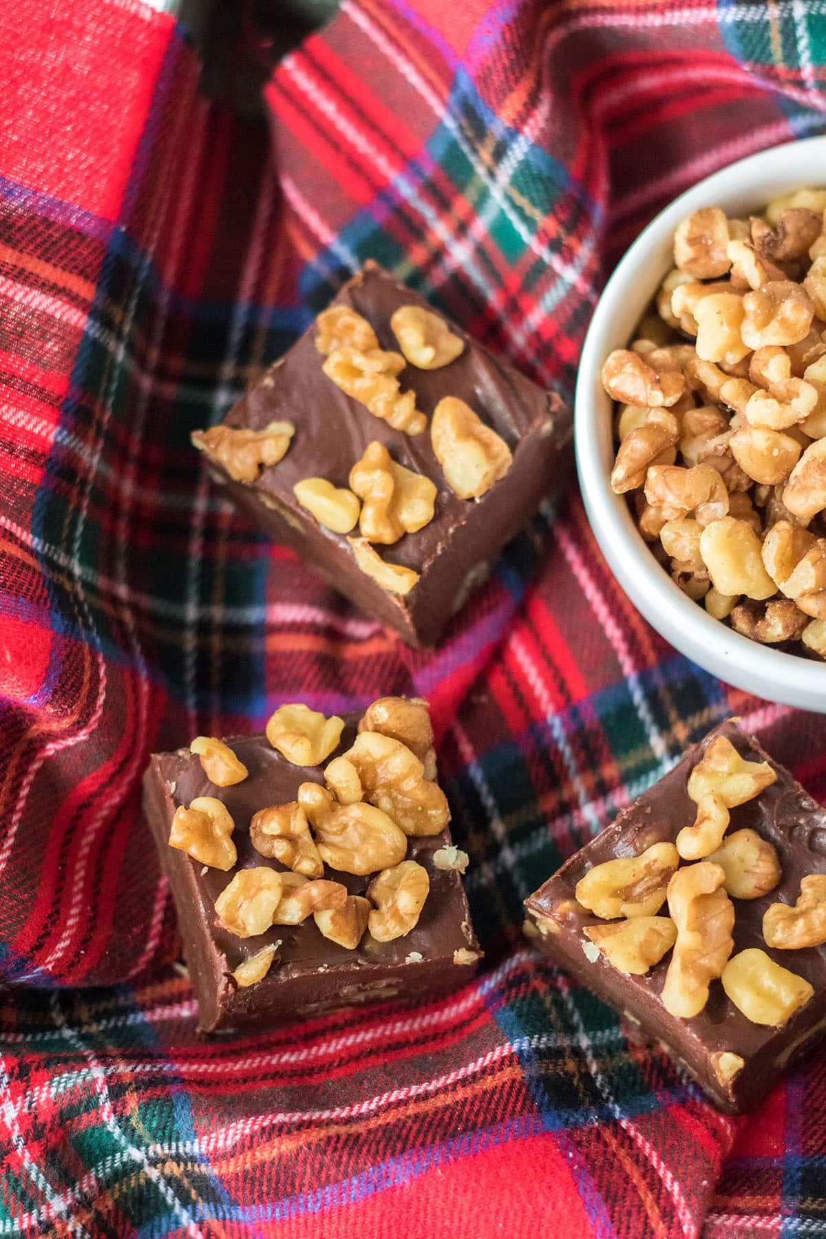 Three slices of Coca-Cola fudge in a bar shape with bowl of walnuts