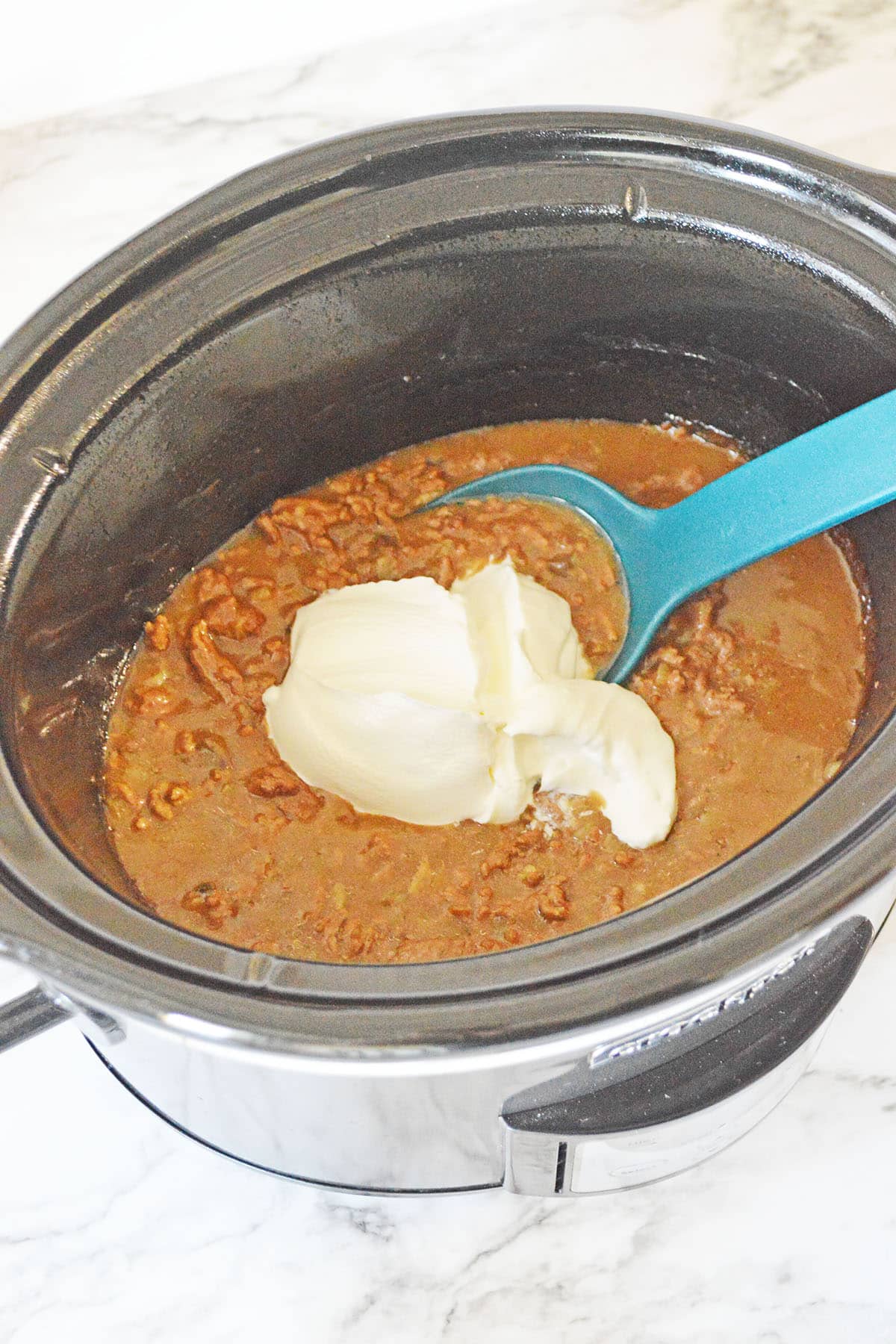 A savory crockpot ground beef stroganoff with sour cream on top