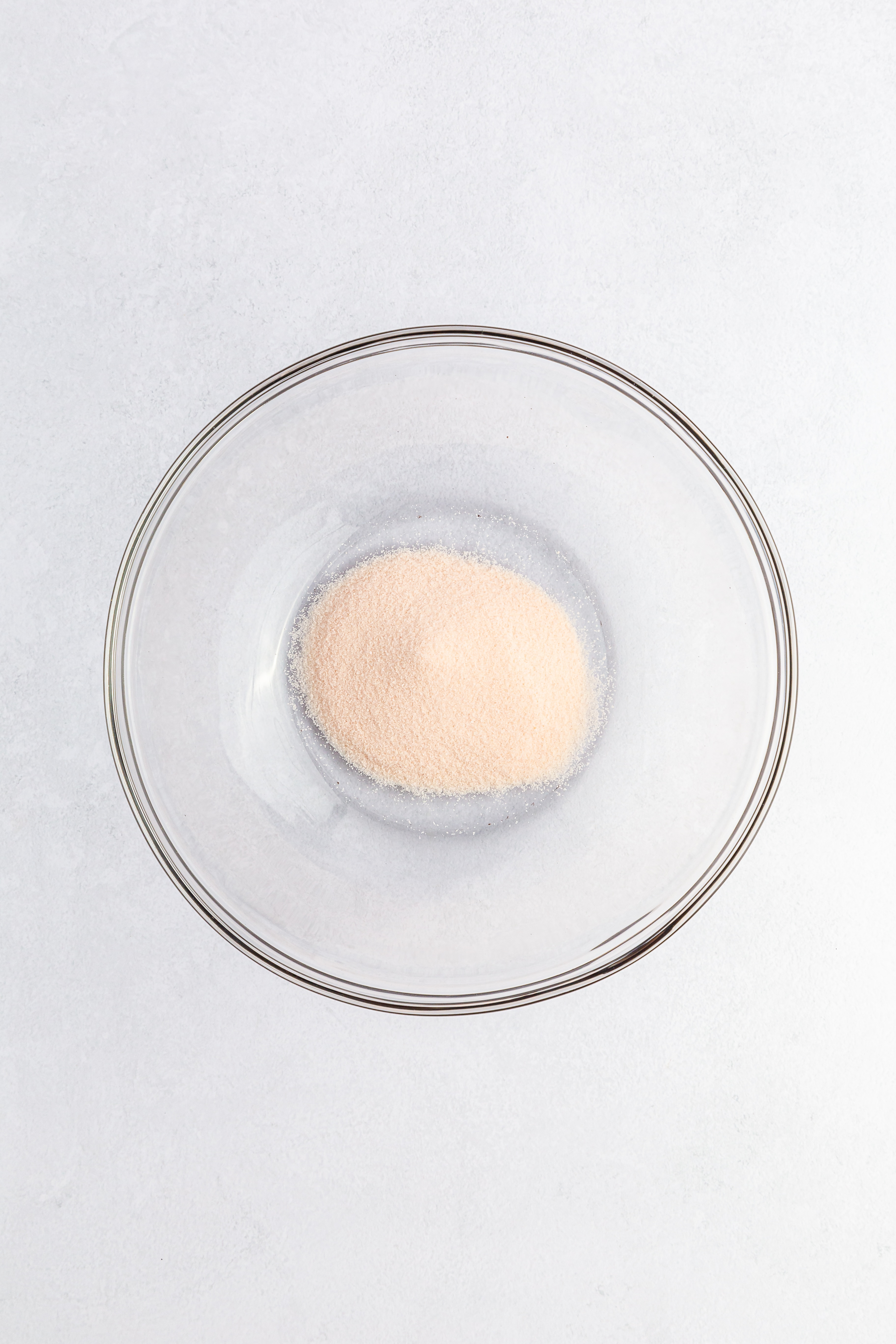 Orange Jell-O mix powder in a glass bowl