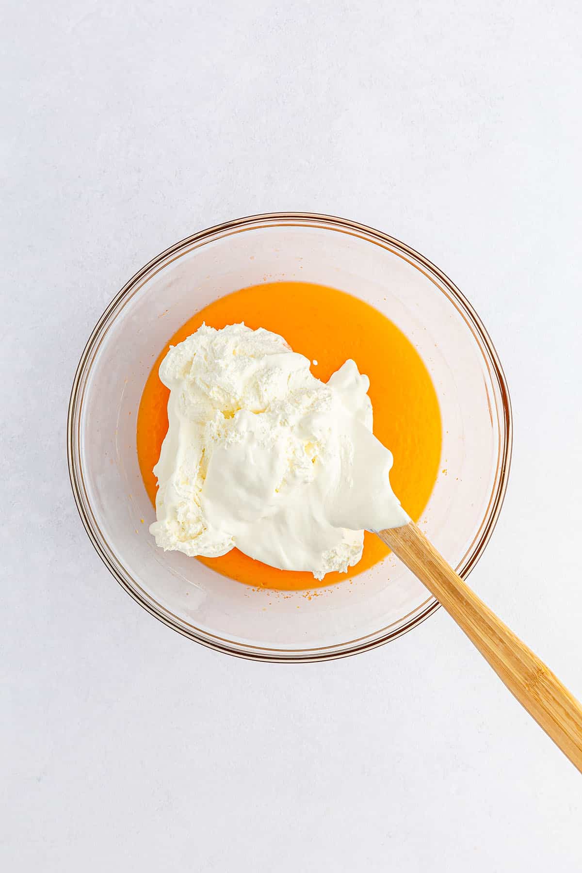 Orange pudding mixture with whipped cream on top
