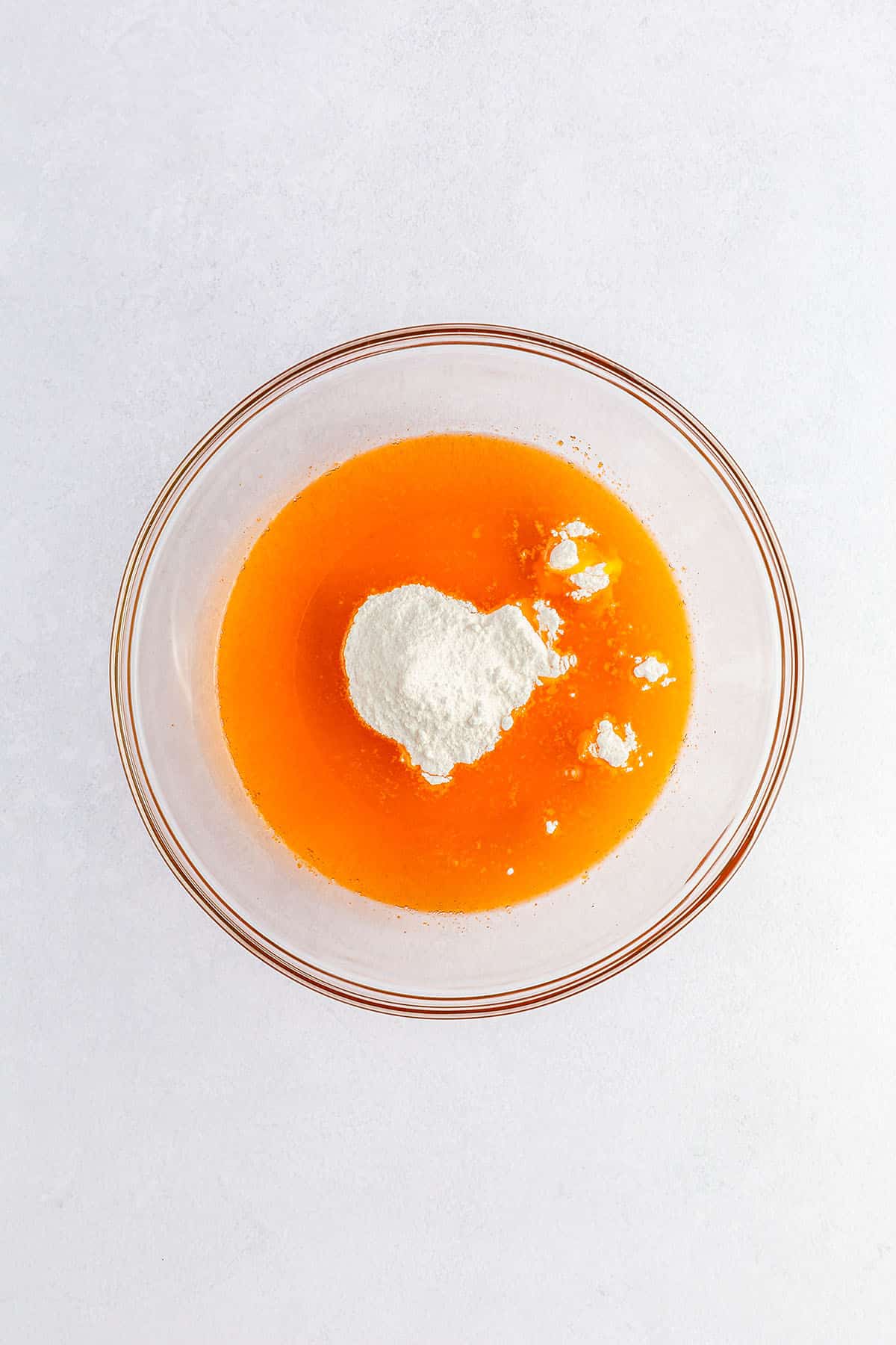 Vanilla pudding powder on top of orange Jell-O mix