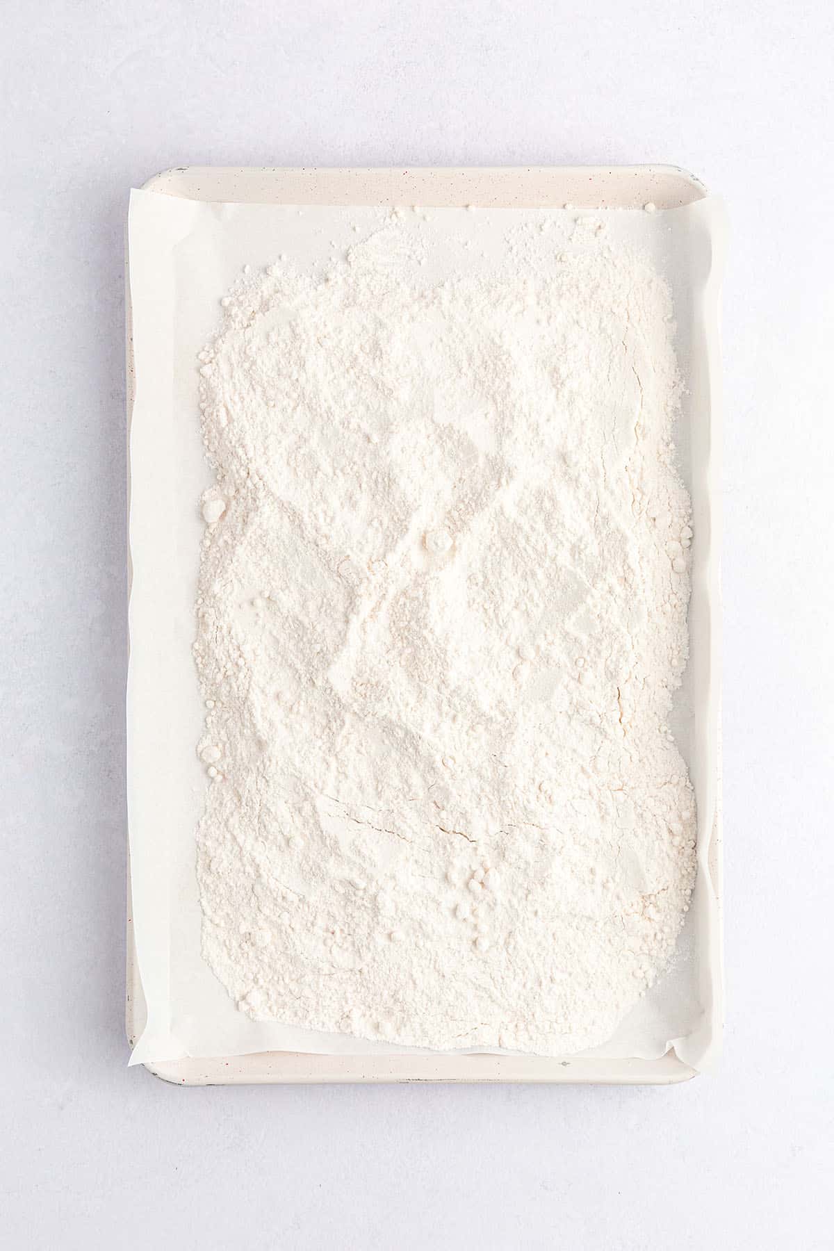 A parchment-lined baking sheet with cake mix powder