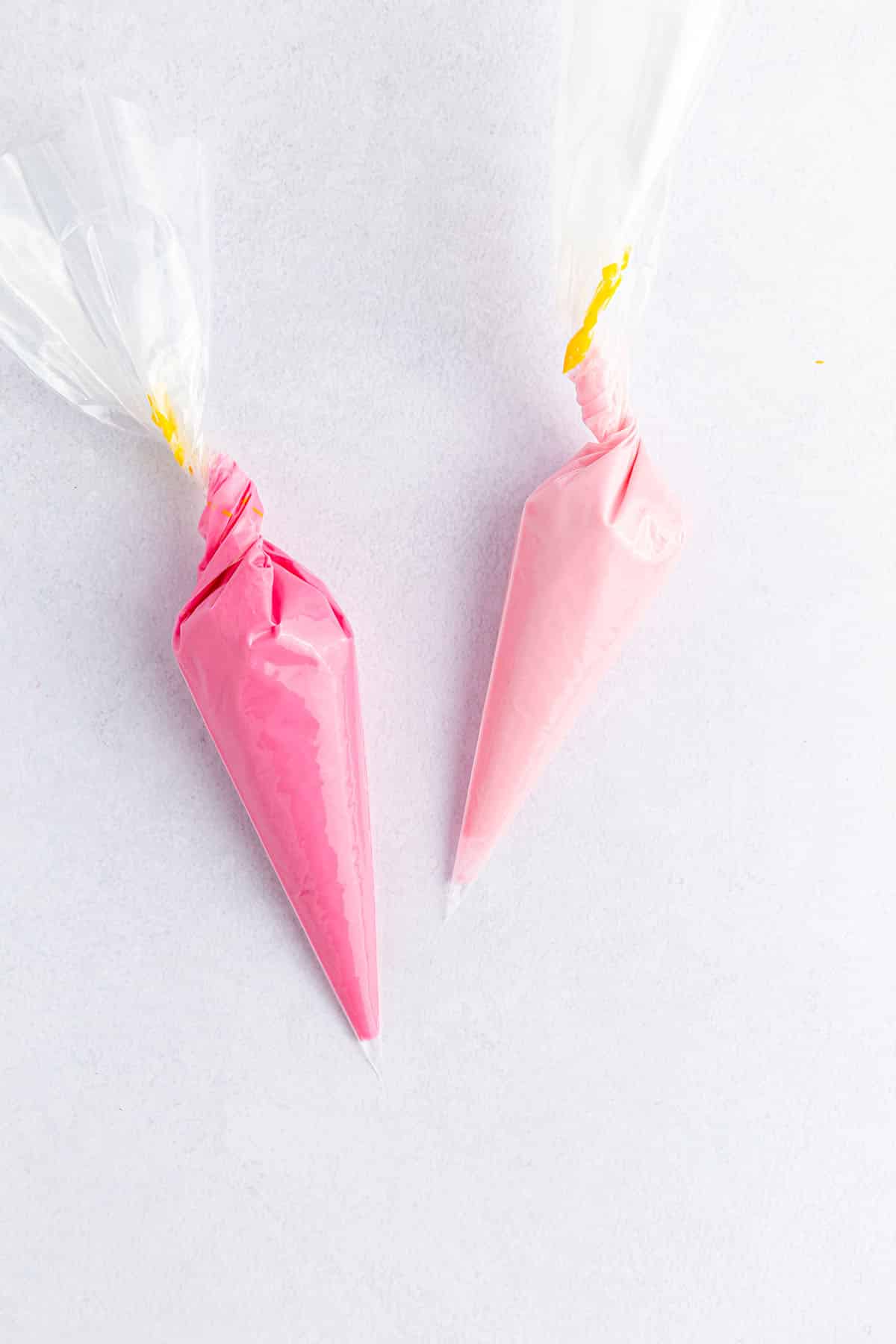 Piping bags in two pink melted chocolates