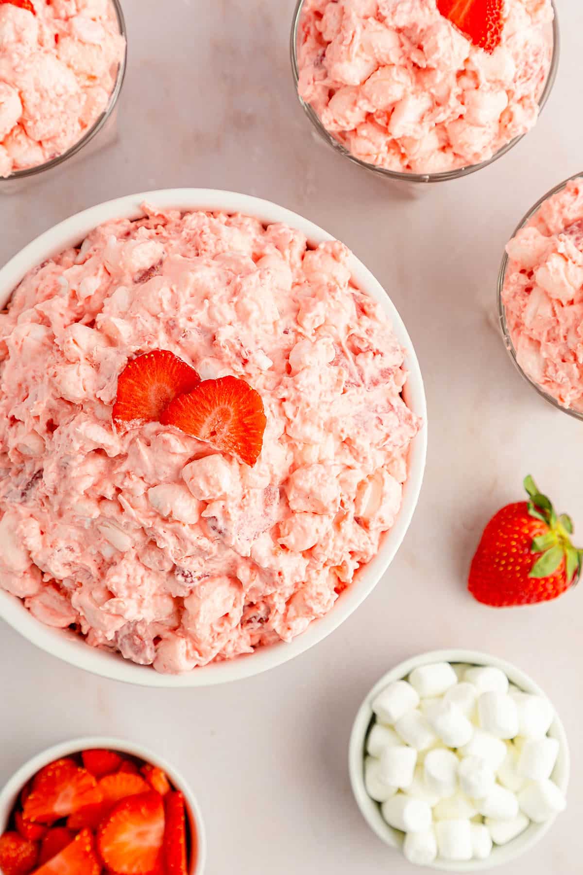A ready to serve strawberry fluff salad with fresh strawberries and mallows in ramekins
