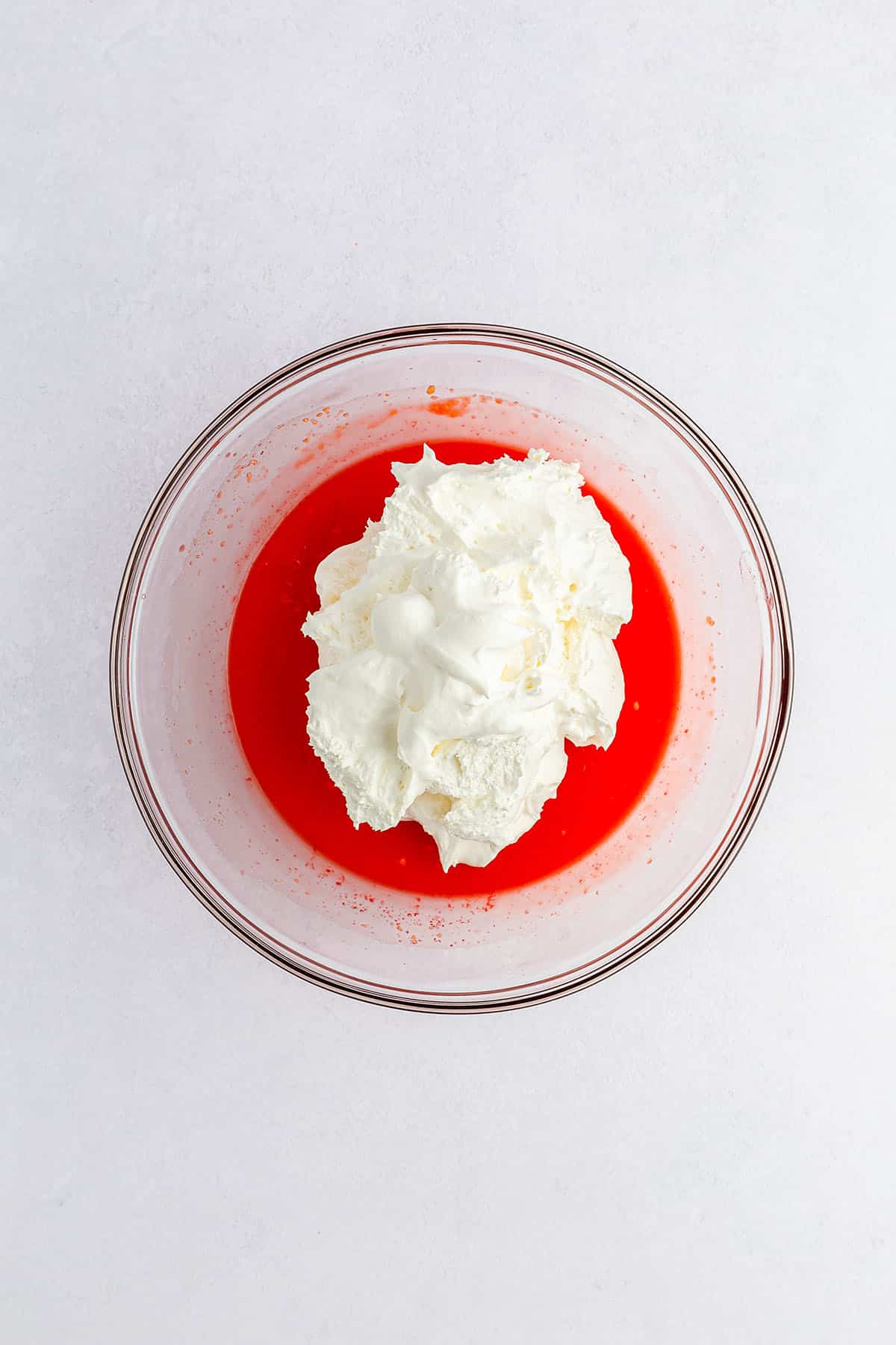 Pudding mixture topped with Cool Whip in glass bowl