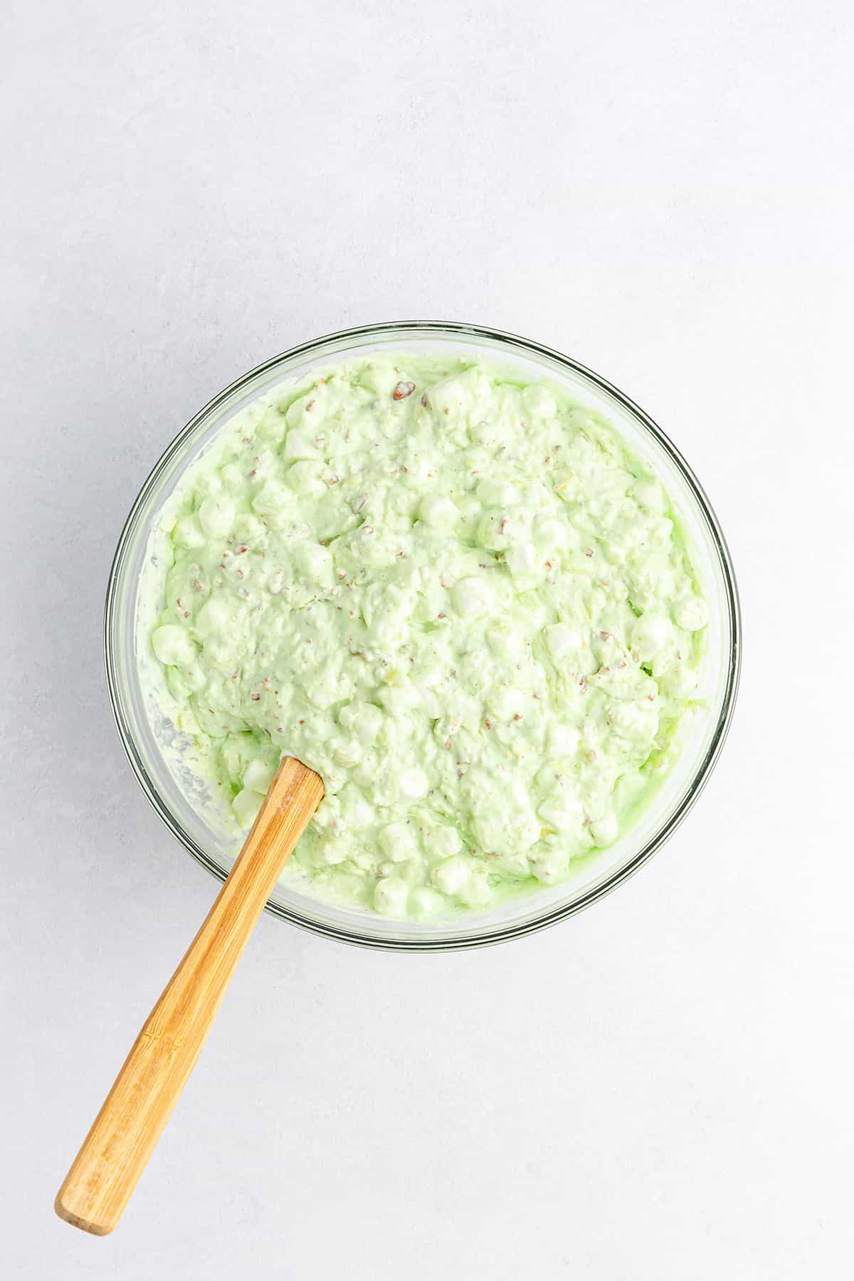 Perfectly creamy Watergate salad in a glass bowl with a spatula
