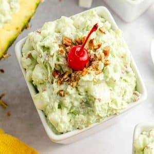 Watergate salad in a square bowl with lovely of toppings