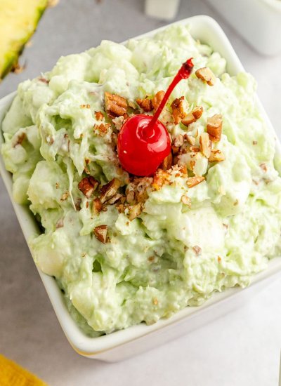 Watergate salad in a square bowl with lovely of toppings