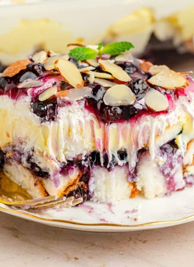 blueberry layer cake on white plate with a bite out