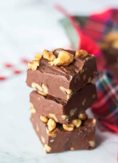 A stack of chocolate fudge with walnuts on top.