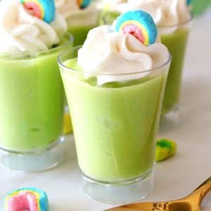 green pudding with whipped cream and candy rainbow on top