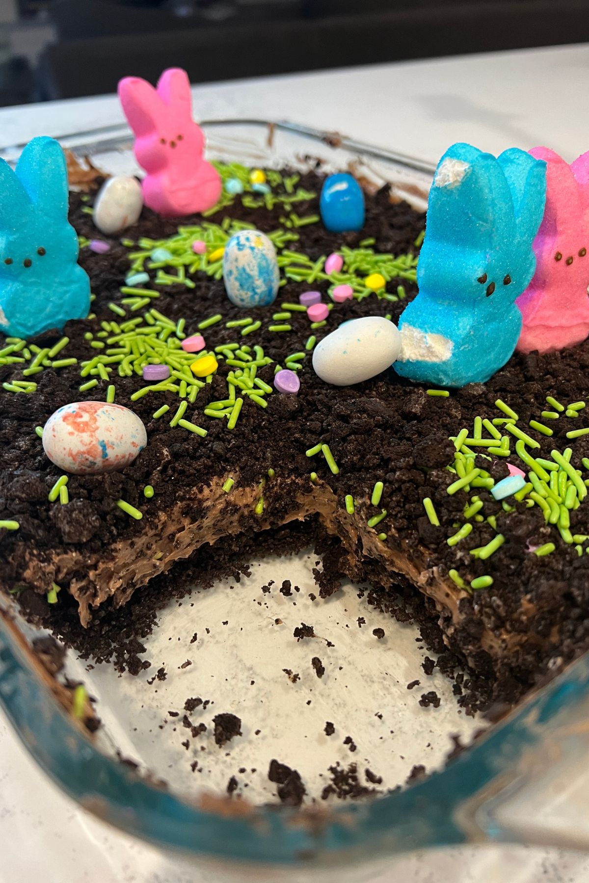 blue and pink bunny peeps on top of a dirt cake