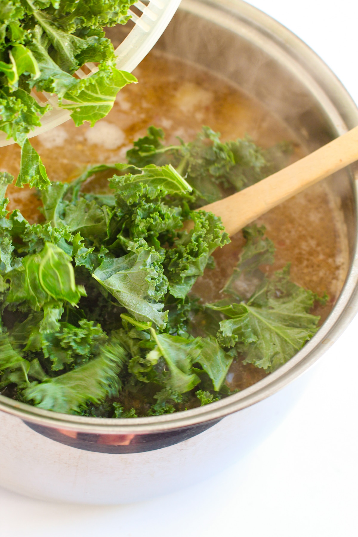 Next process in preparing Olive Garden Zuppa Toscano Soup is to add kale to the mixture.