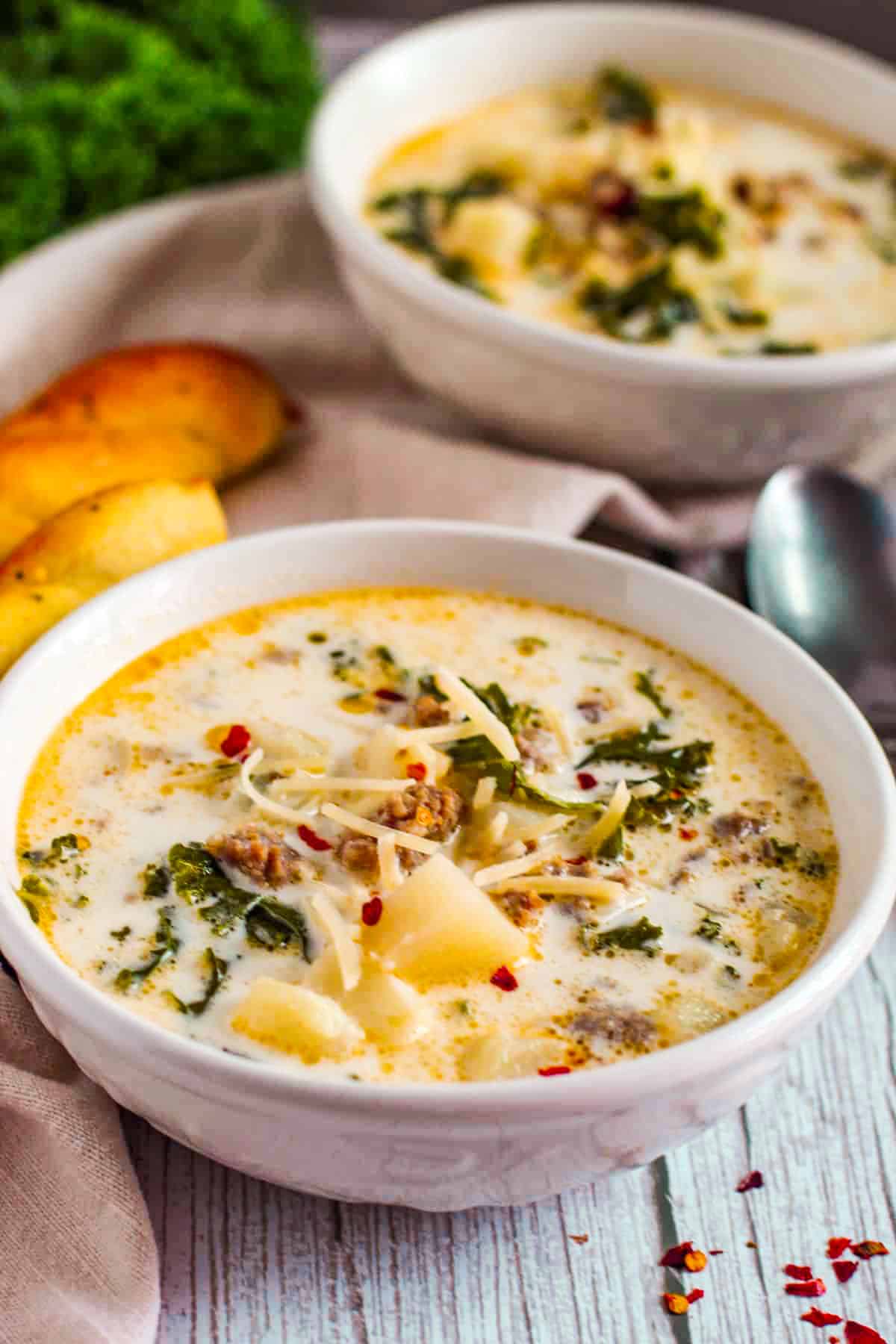 creamy soup with potato and kale poking out of the top