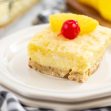 A slice of Pineapple Cheesecake Bar on a white plate