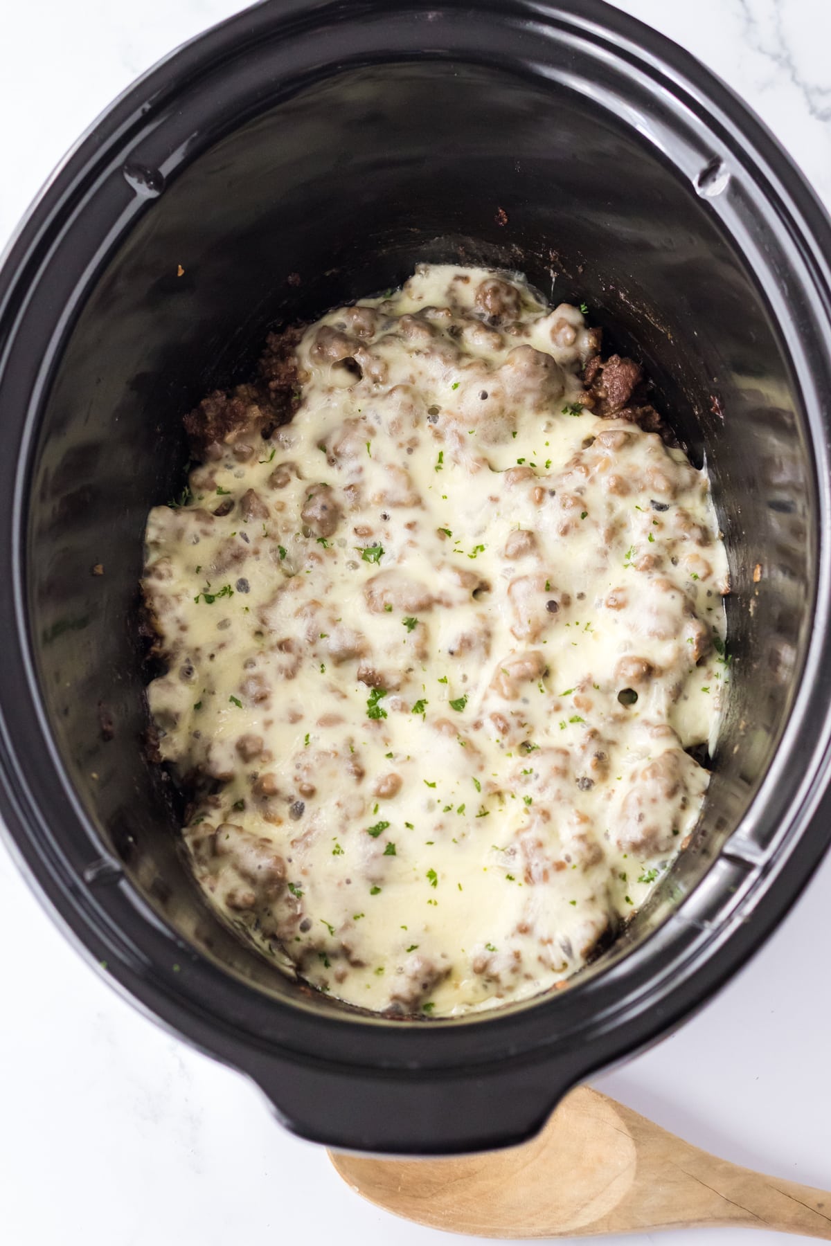 Adding the cheese on top of the mixture is another process of preparing Slow Cooker French Dip Sloppy Joes