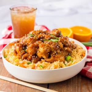 A delicious bowl of Slow Cooker Orange Chicken with linen on the side