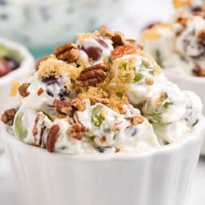 green grapes with cream cheese mixture, pecans, and brown sugar in white bowl