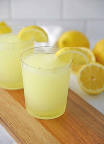 A glass of Lemonade Slushie on a wooden counter