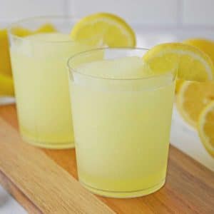 Two glasses of Lemonade Slushies on a wooden table
