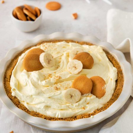A bowl of Banana Pudding Pie with garnish on a white linen.