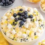 light yellow fluff in bowl with marshmallows and blueberries on top