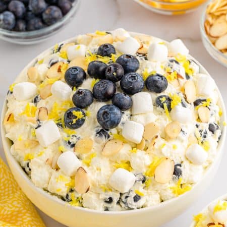 light yellow fluff in bowl with marshmallows and blueberries on top
