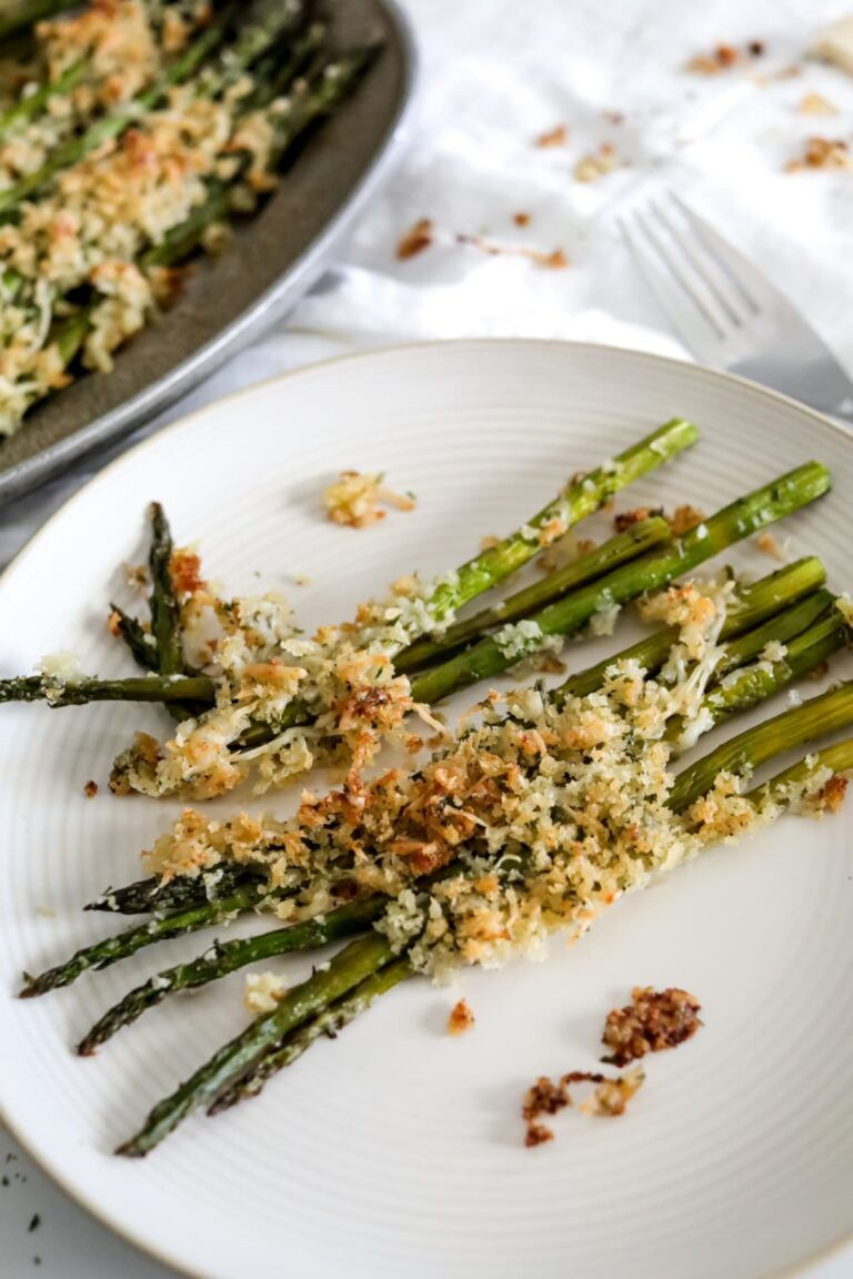 A plate of asparagus topped with breadcrumbs and parmesan is perfect to serve with spaghetti.