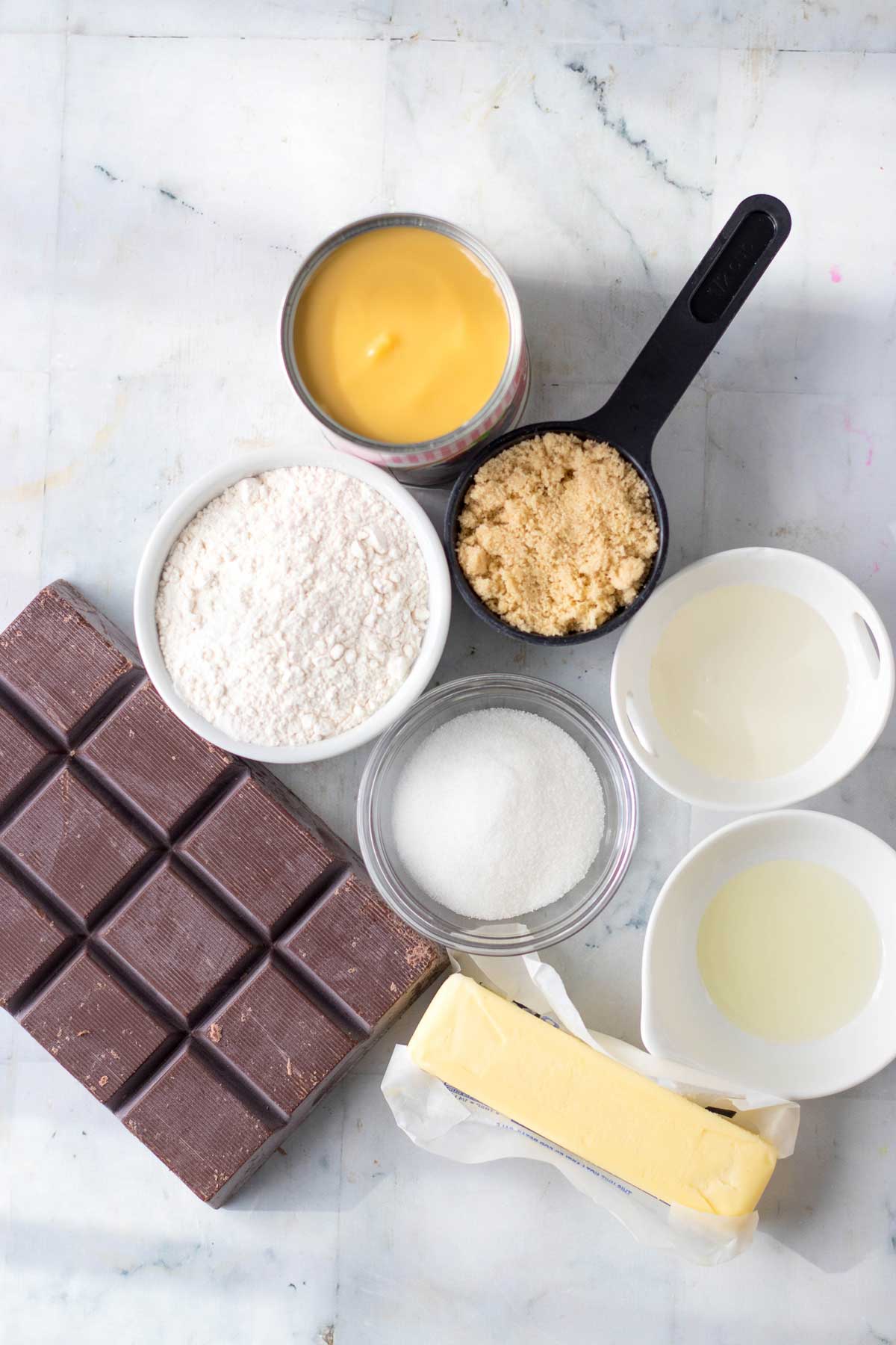 Ingredients for Homemade Twix Bars include granulated sugar, flour, butter- slightly softened, light brown sugar, butter, sweetened condensed milk, corn syrup, chocolate almond bark and oil- (melted coconut oil or vegetable oil for best results)