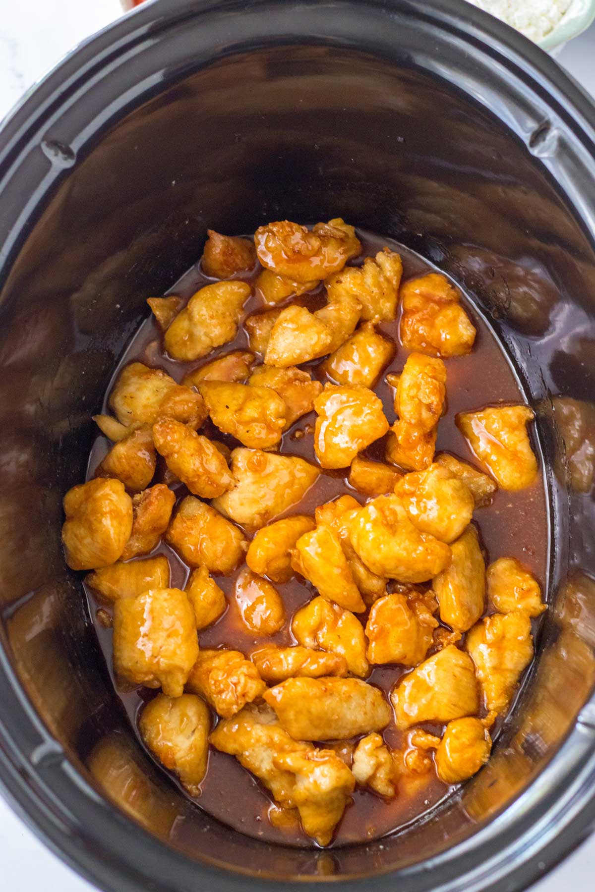 Adding the sauce to the chicken is another process in preparing Slow Cooker Firecracker Chicken