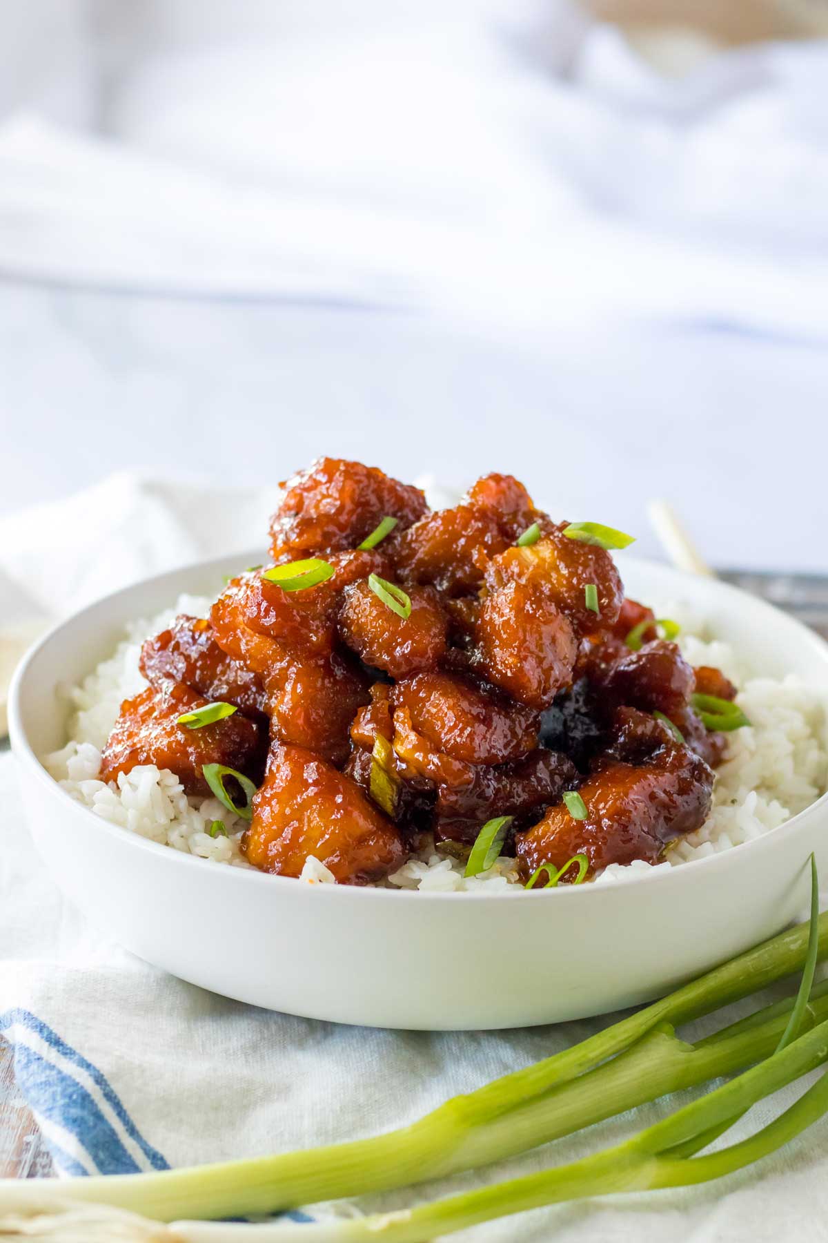 A bowl of Slow Cooker Firecracker Chicken with rice and linen.