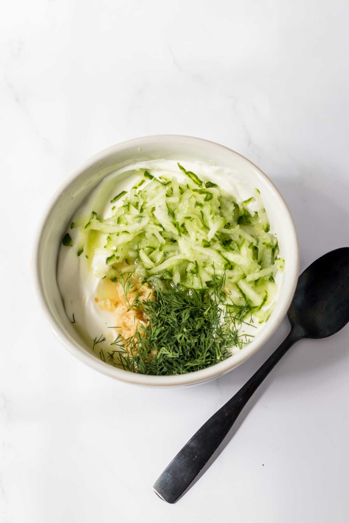 Plain Greek yogurt, grated English cucumbers and fresh dill for Slow Cooker Gyros